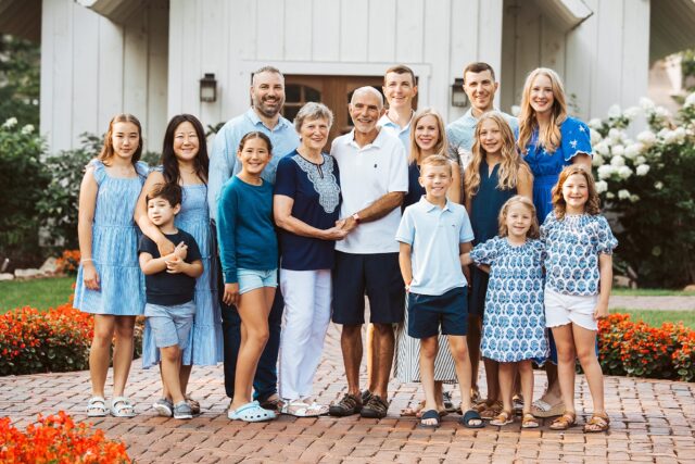 An extended family photography session at Grand View Lodge in Nisswa, MN. The group is standing in front of a white chapel on the resort property.