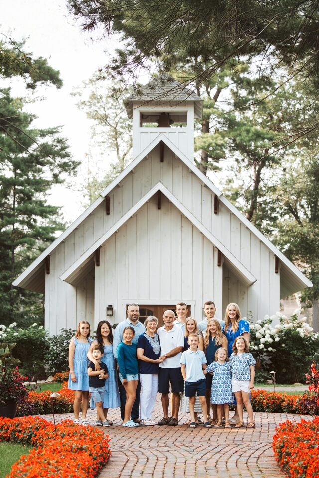 Family photo at the Grand View Lodge Chapel in Nisswa, MN. The family is wearing shades of blue and they are gathered for a family reunion in the Brainerd Lakes Area